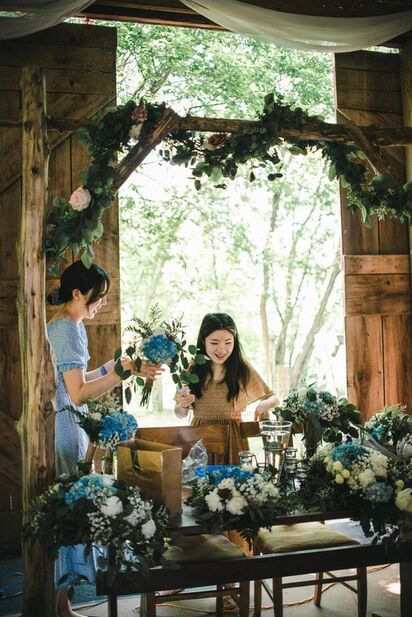 Two women prepare flowers for a ceremony with the extra time they are given that is included in our wedding package pricing.