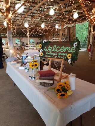 A sign welcomes guests inside one of the original vermont wedding venues that is decorated with lanterns and flowers for a reception.